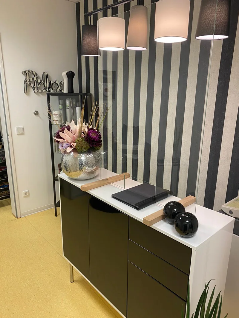 Salon-Detail bei CUT: Empfang mit Blumen, Streifentapete und warmem Licht